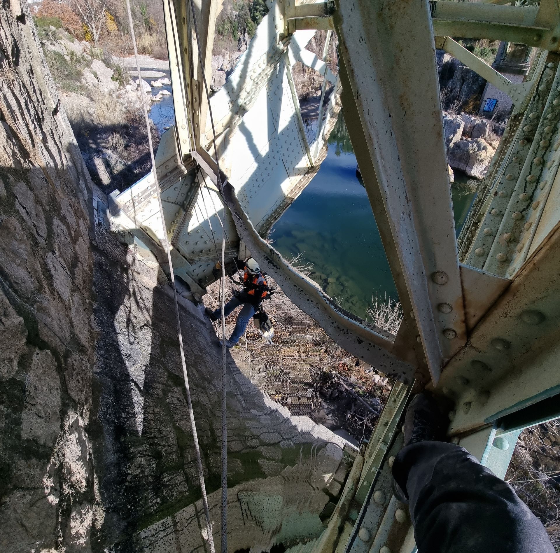 Une personne se tient sur un pont au-dessus d'un plan d'eau