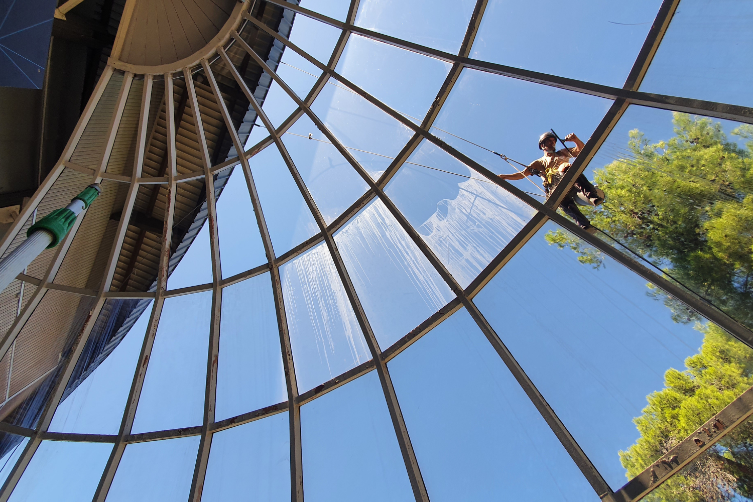 Un homme nettoie un dôme en verre avec un balai
