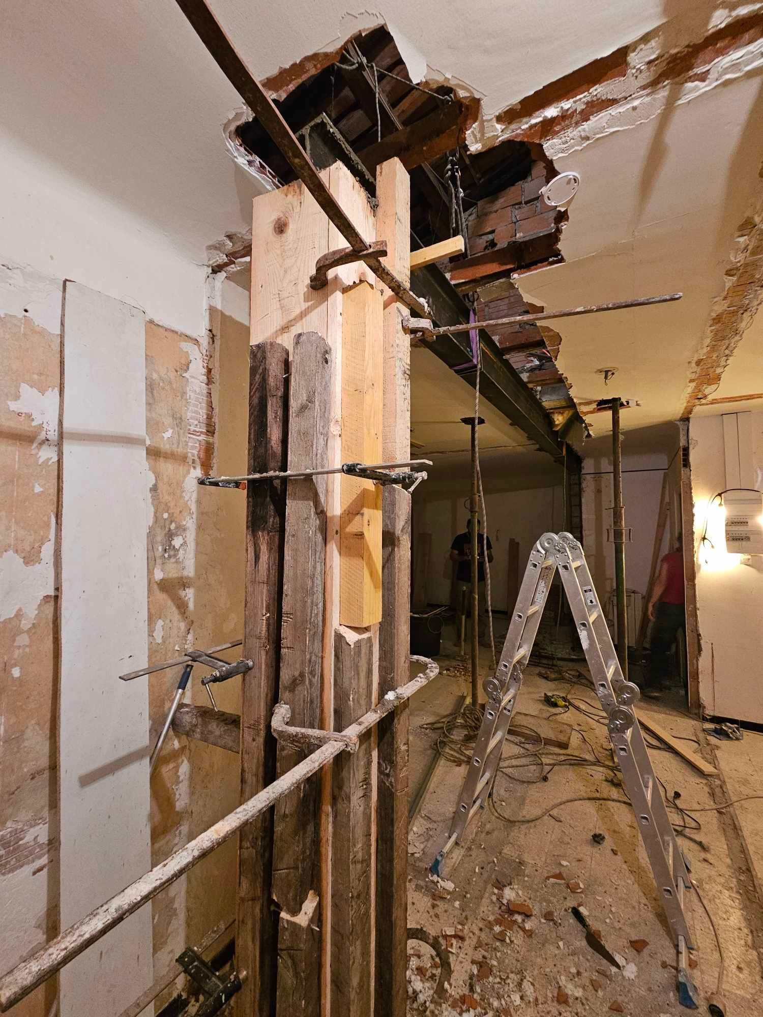 Une échelle est posée au milieu d'une pièce en construction.