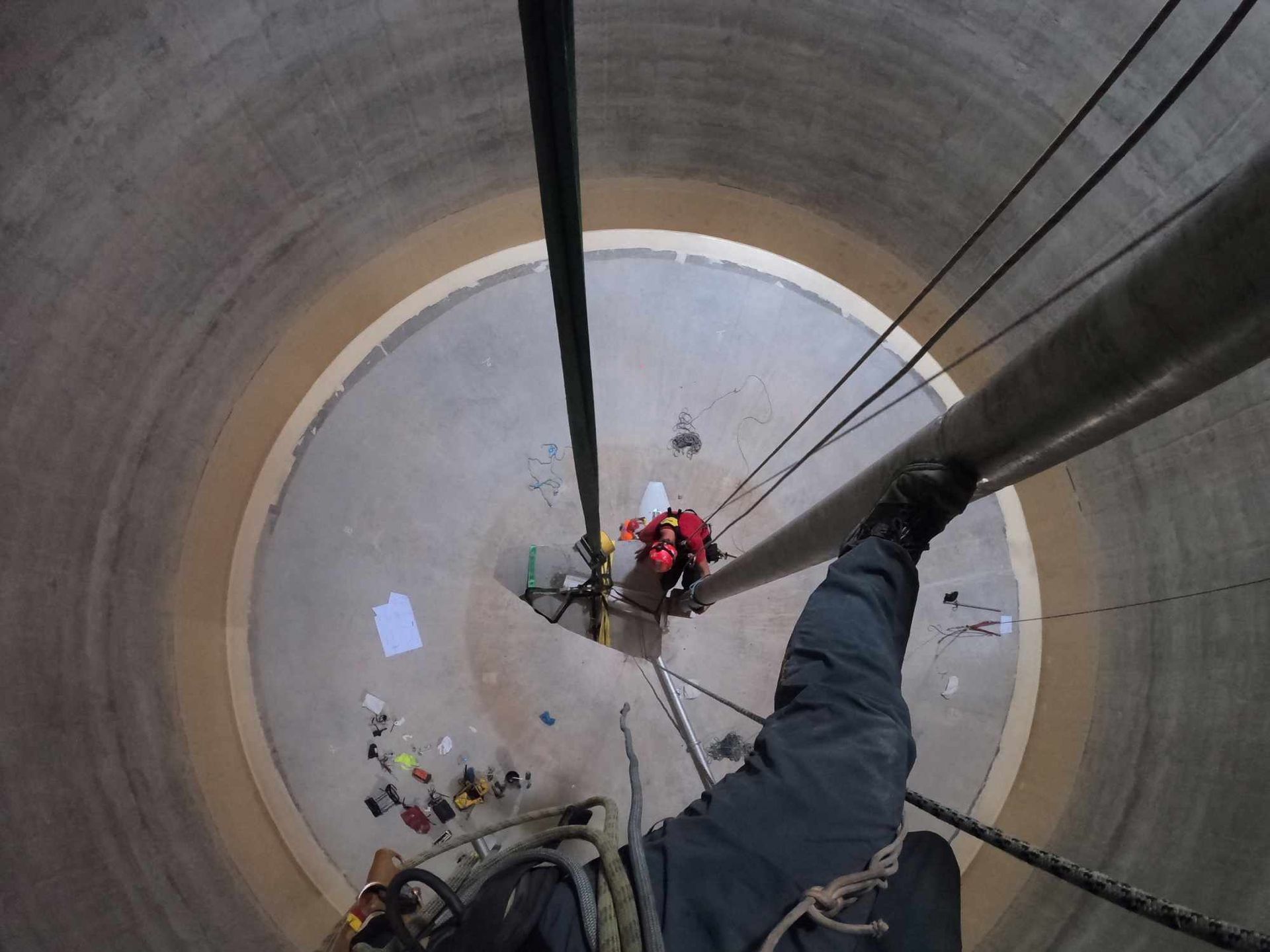 Un homme est suspendu à une corde dans une structure circulaire.