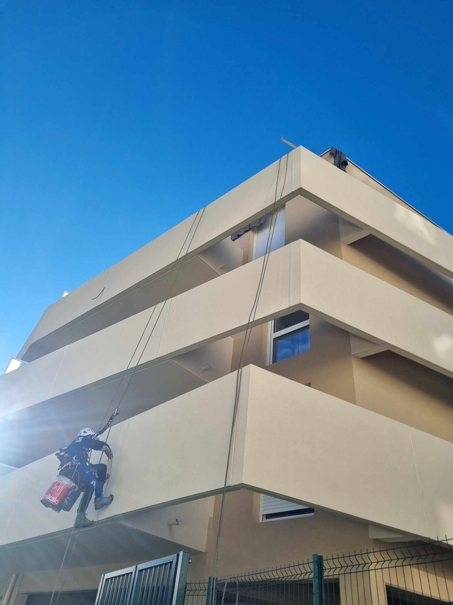 Un homme grimpe sur le côté d'un bâtiment.