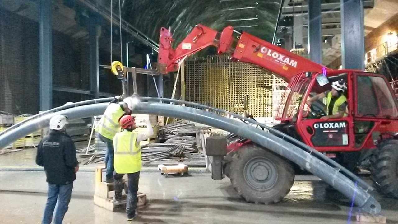 Un groupe d'ouvriers du bâtiment travaille sur un pont dans un bâtiment.