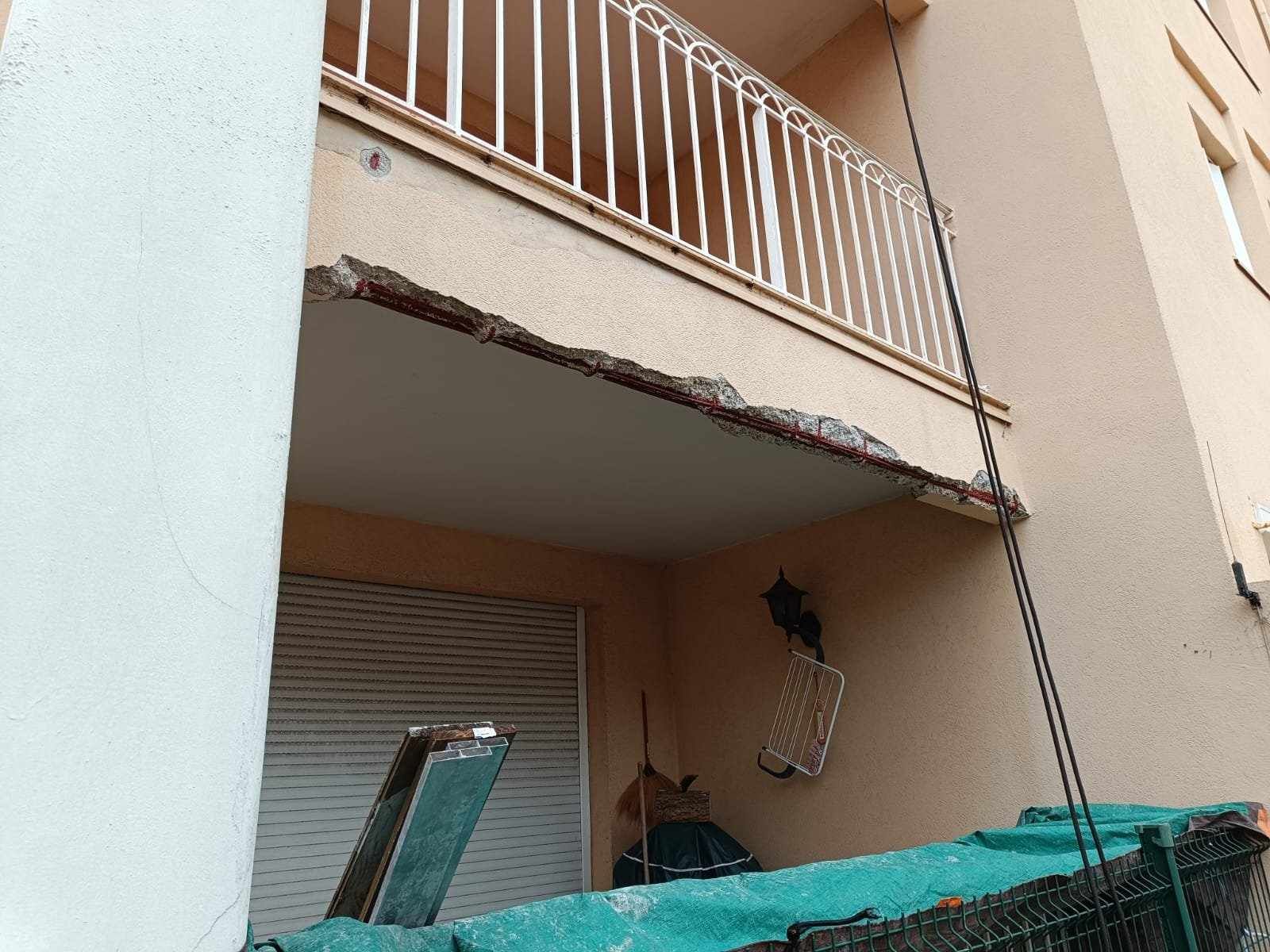 Un balcon sur le côté d'un bâtiment avec une balustrade cassée