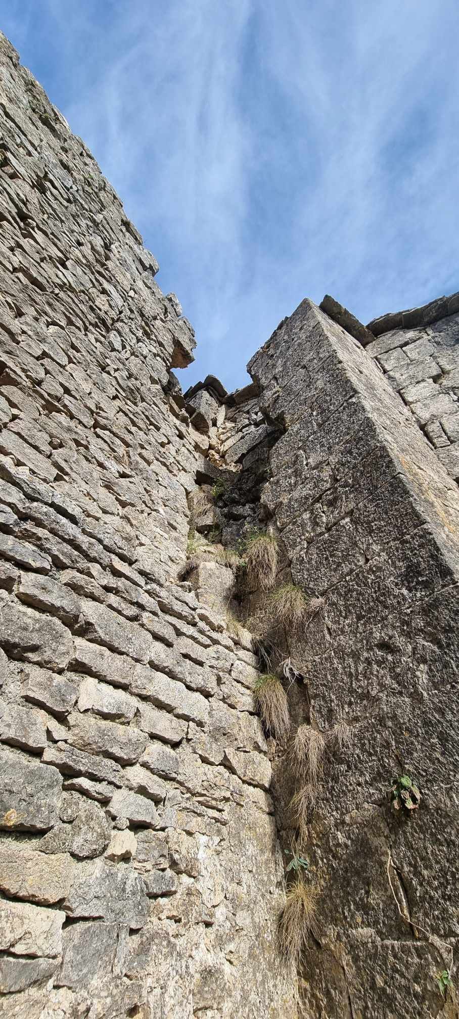 Regardant un mur de pierre avec un ciel bleu en arrière-plan.