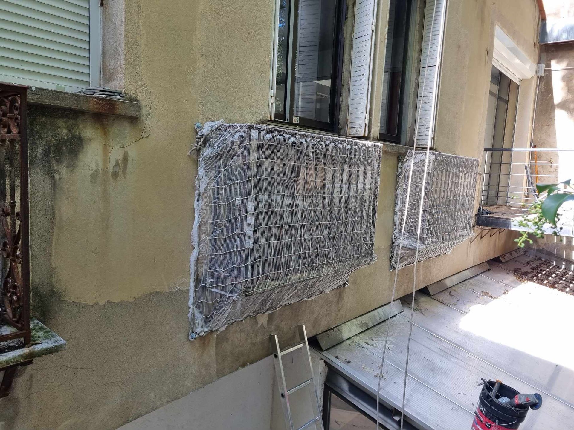 Une échelle est posée sur le côté d'un bâtiment à côté d'une fenêtre.