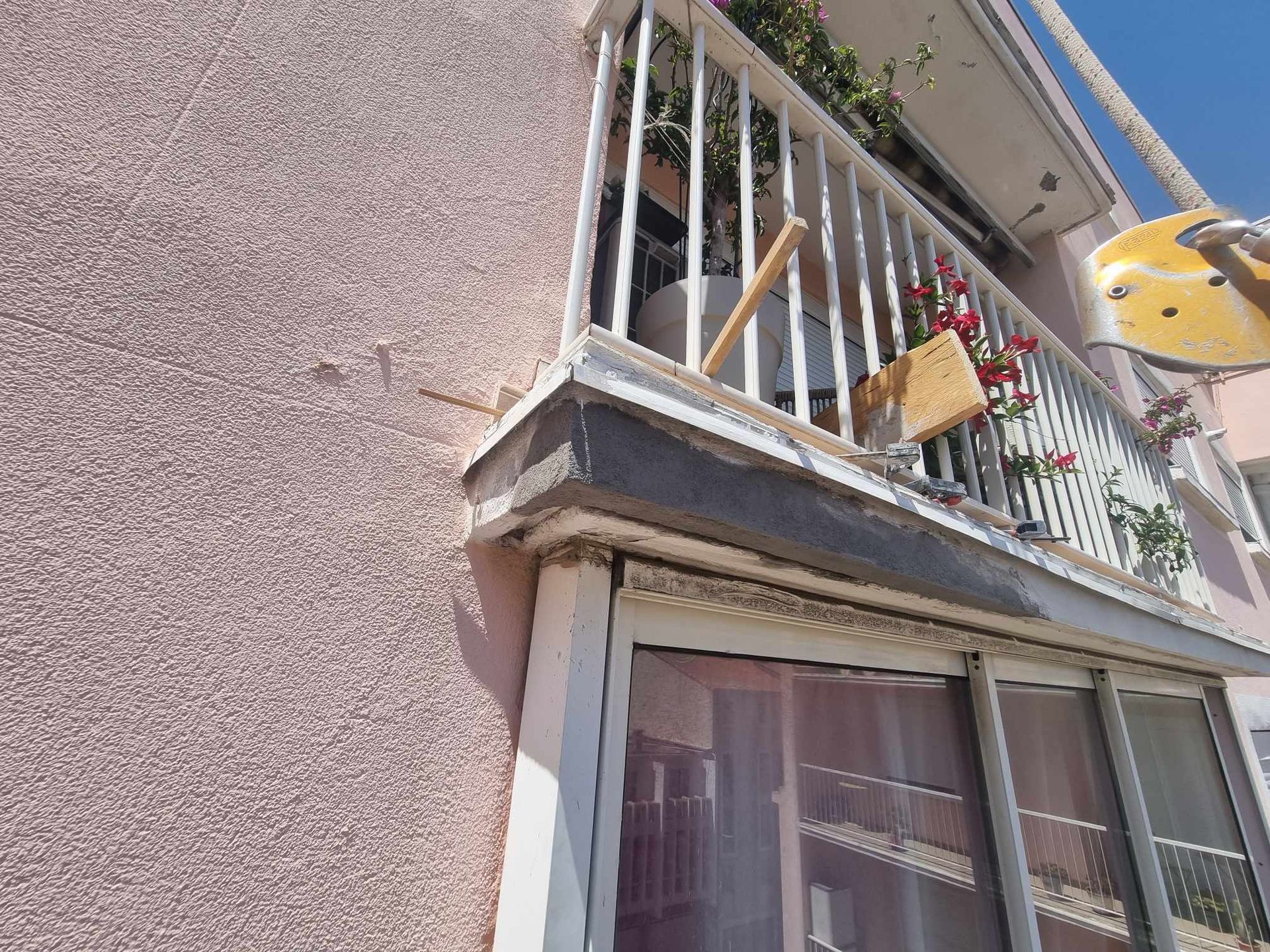 Un balcon sur le côté d'un bâtiment avec un oiseau dessus.