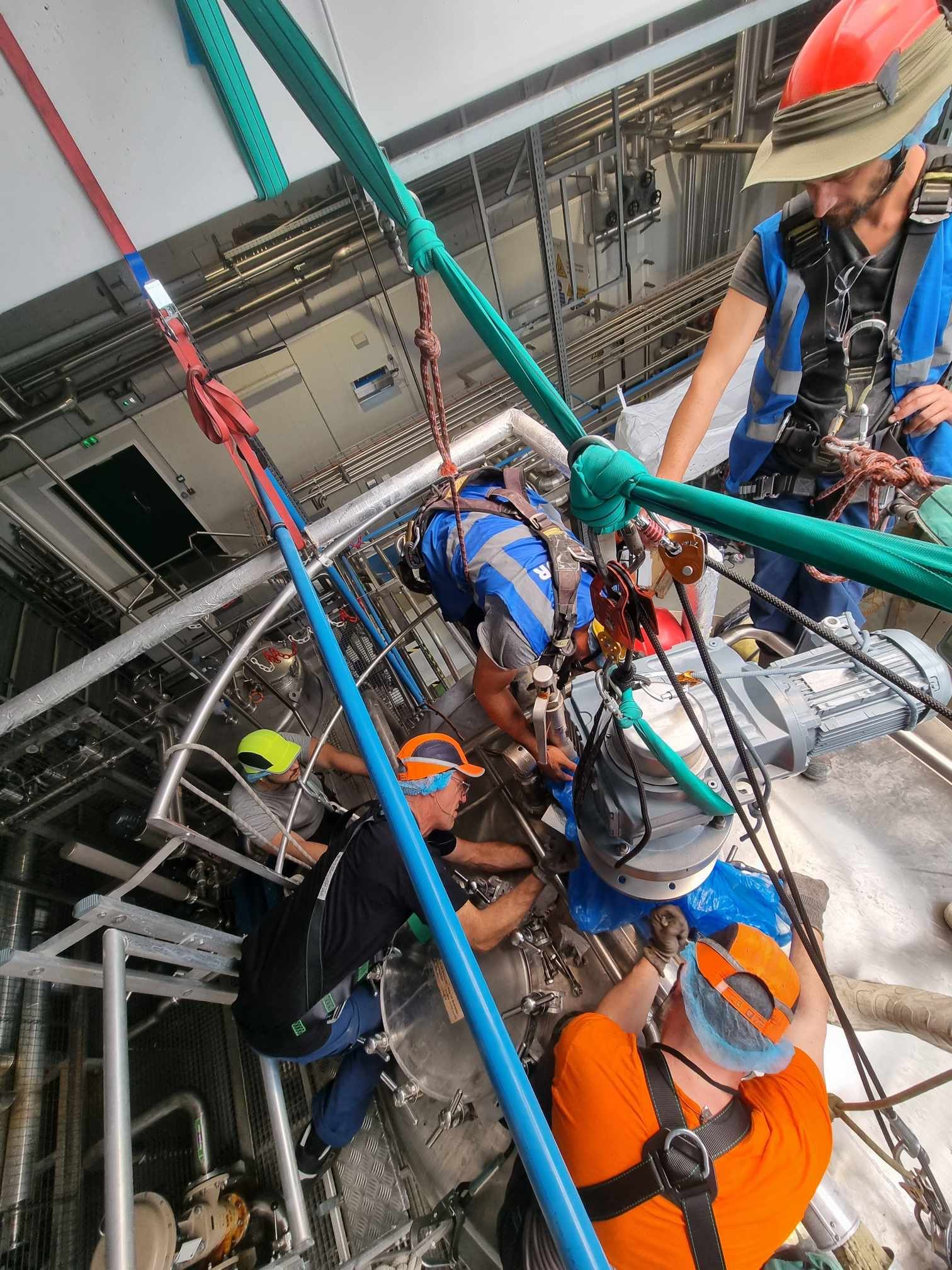 Un groupe d'hommes travaille sur une machine dans une usine.
