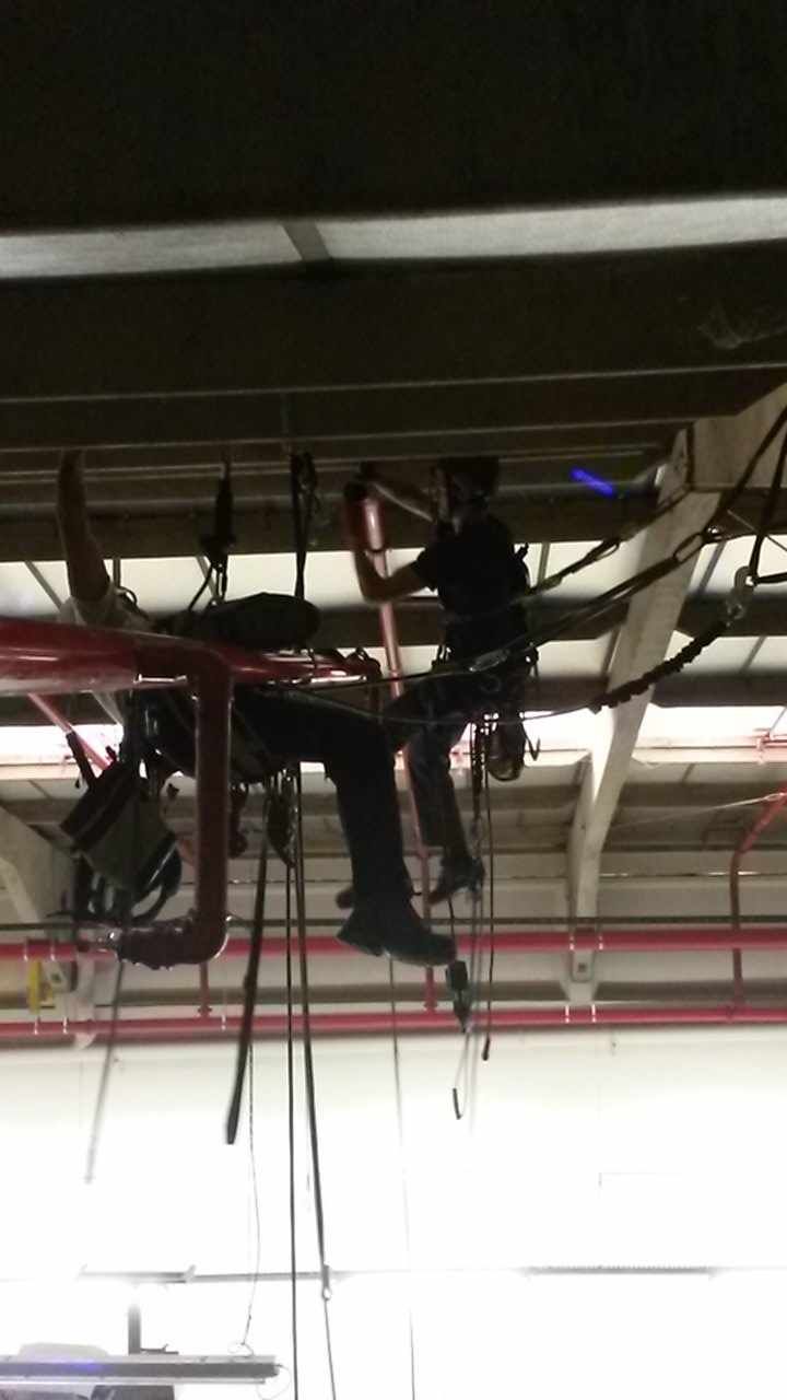 Un homme travaille sur un tuyau dans un bâtiment