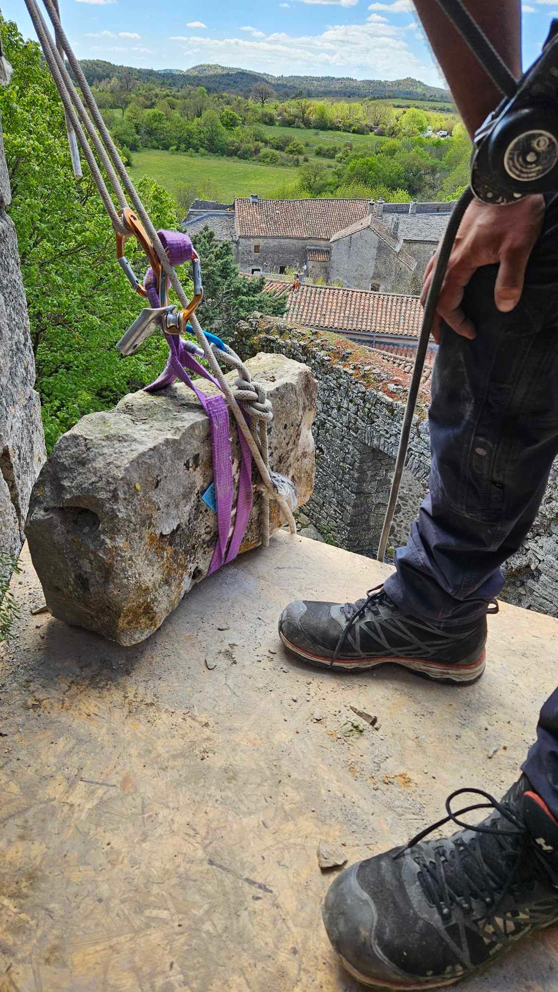 Une personne se tient à côté d'un gros rocher avec une corde attachée.