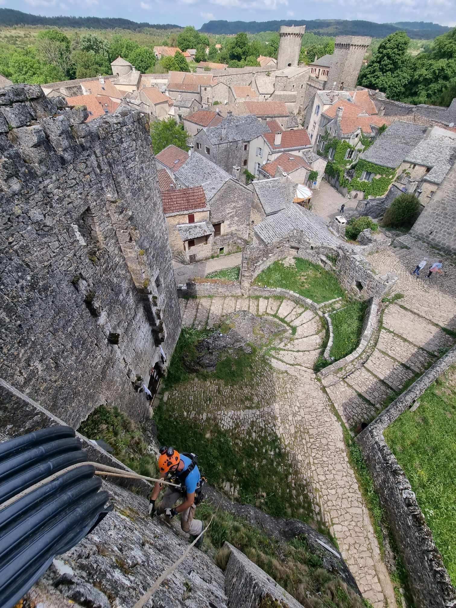 Un homme grimpe sur le flanc d'un château.