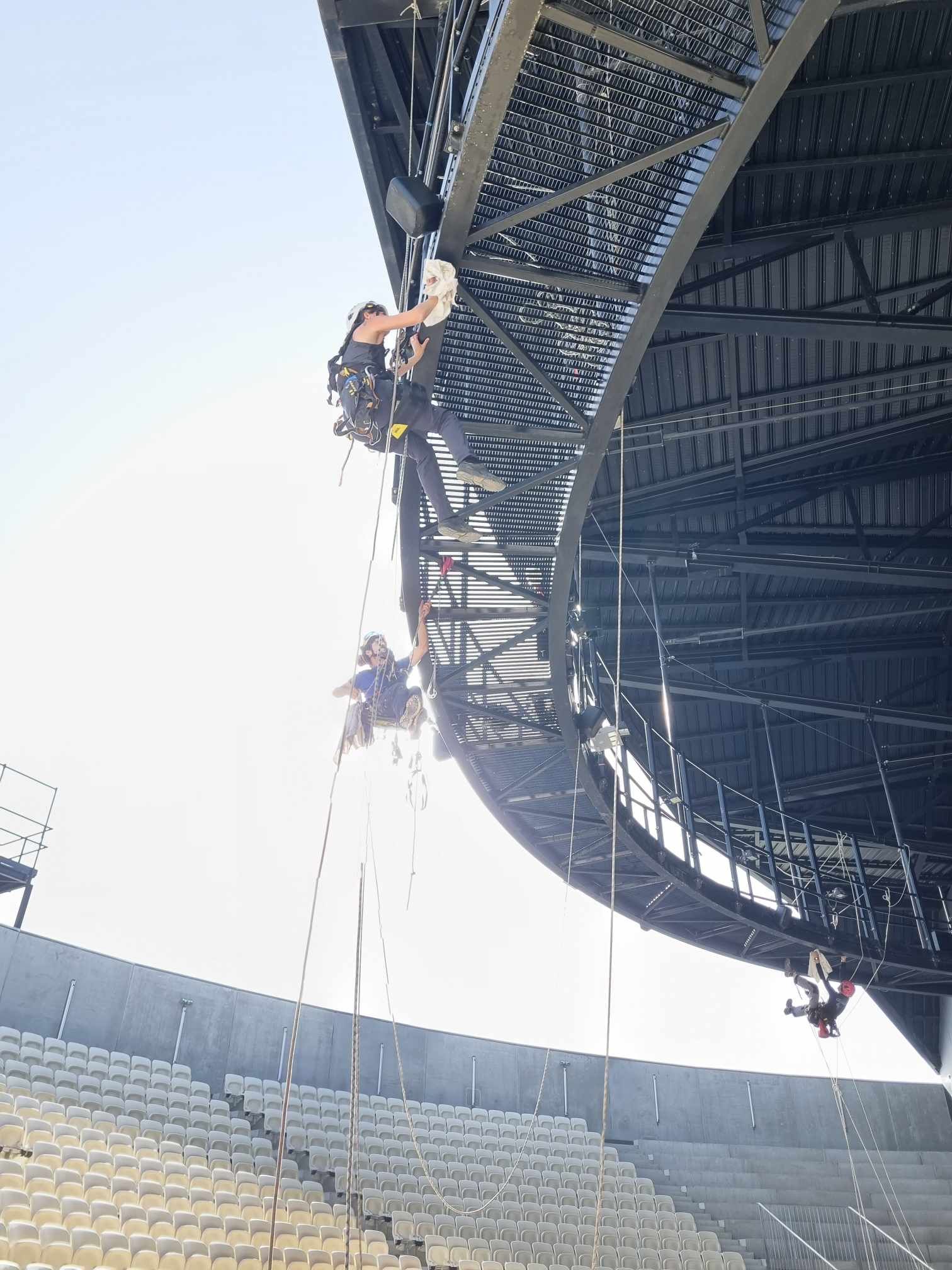 Un groupe de personnes grimpe sur le côté d'un stade.