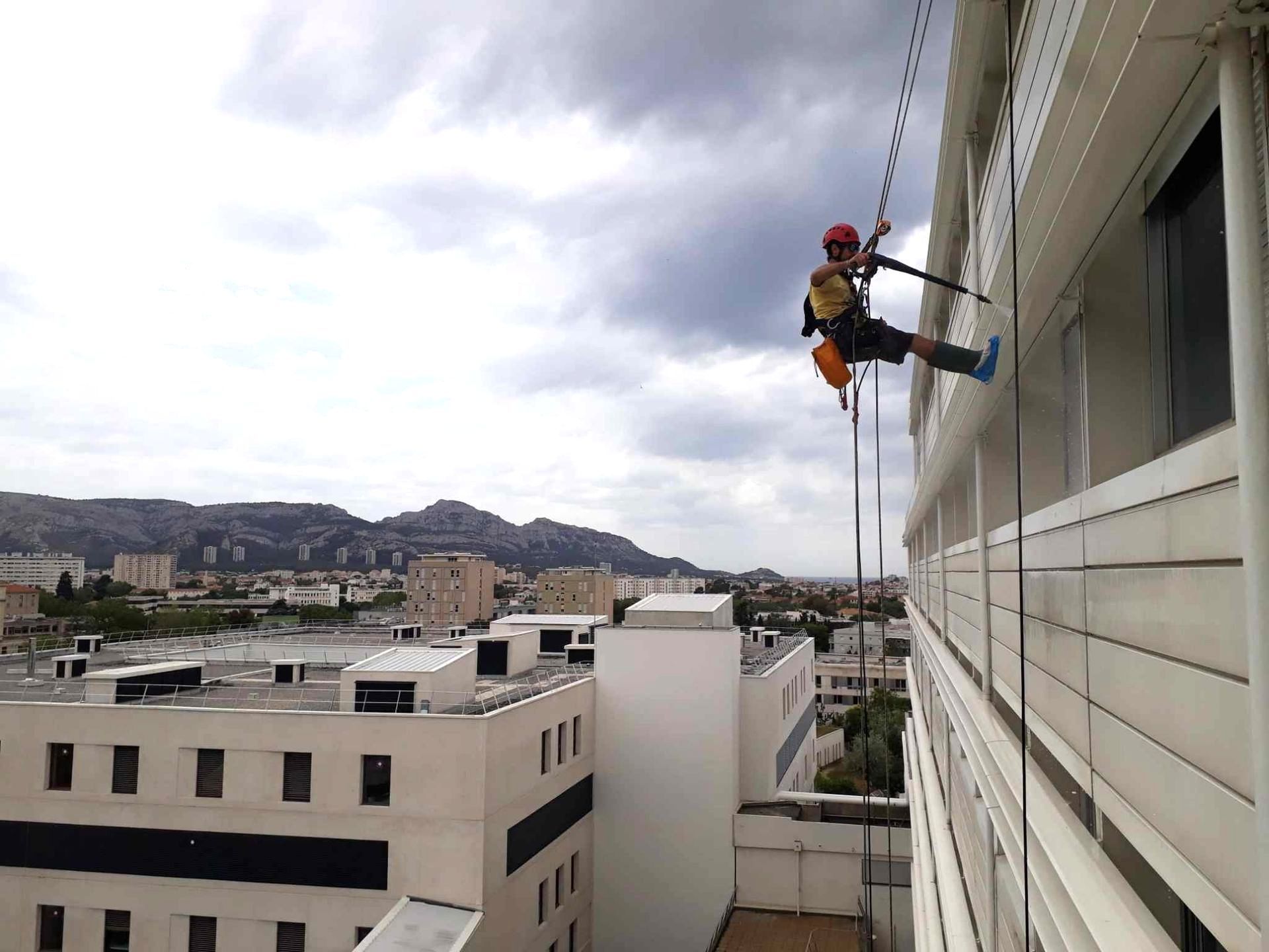 Un homme grimpe sur le côté d'un bâtiment