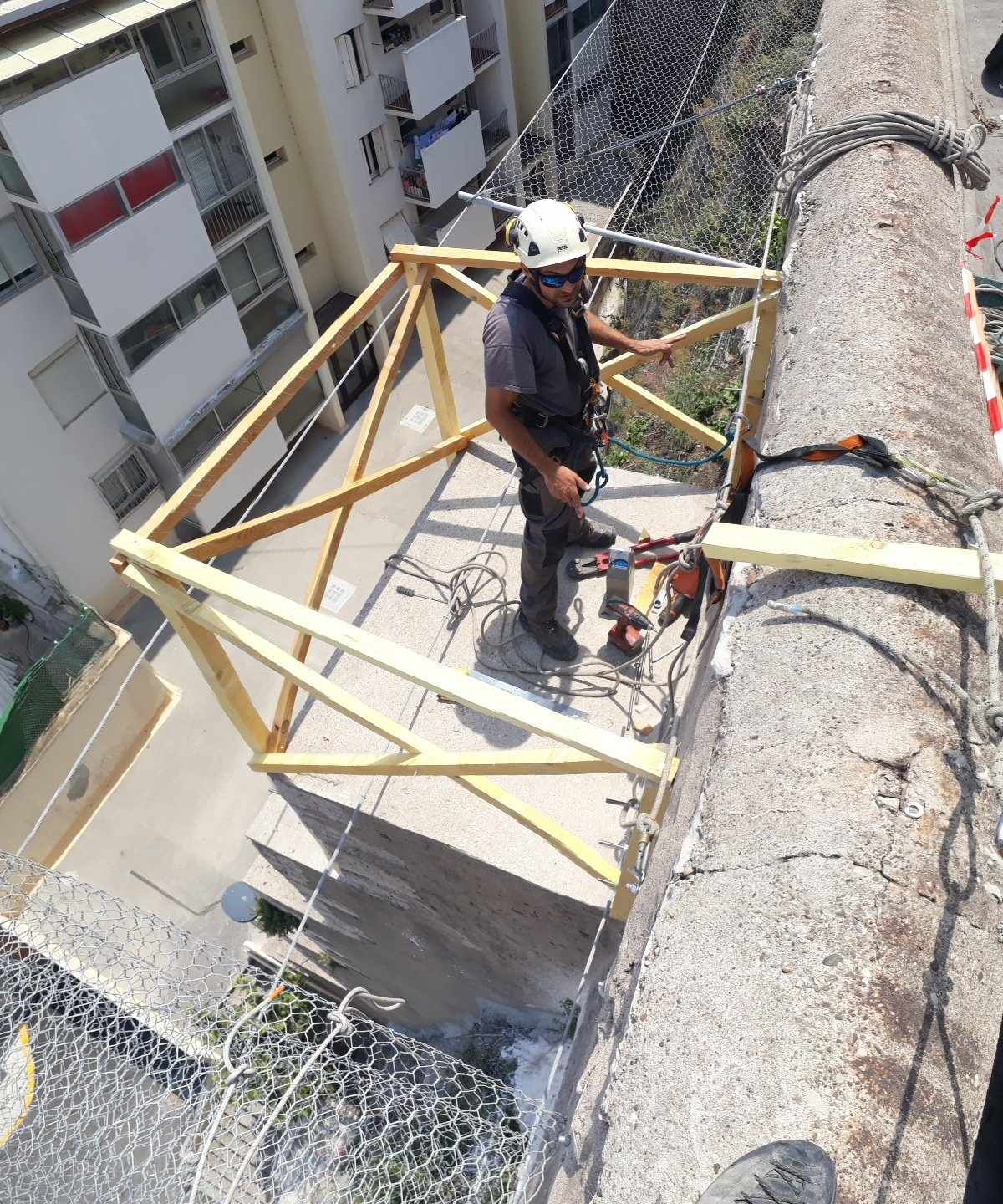 Un homme portant un casque travaille sur une structure en béton