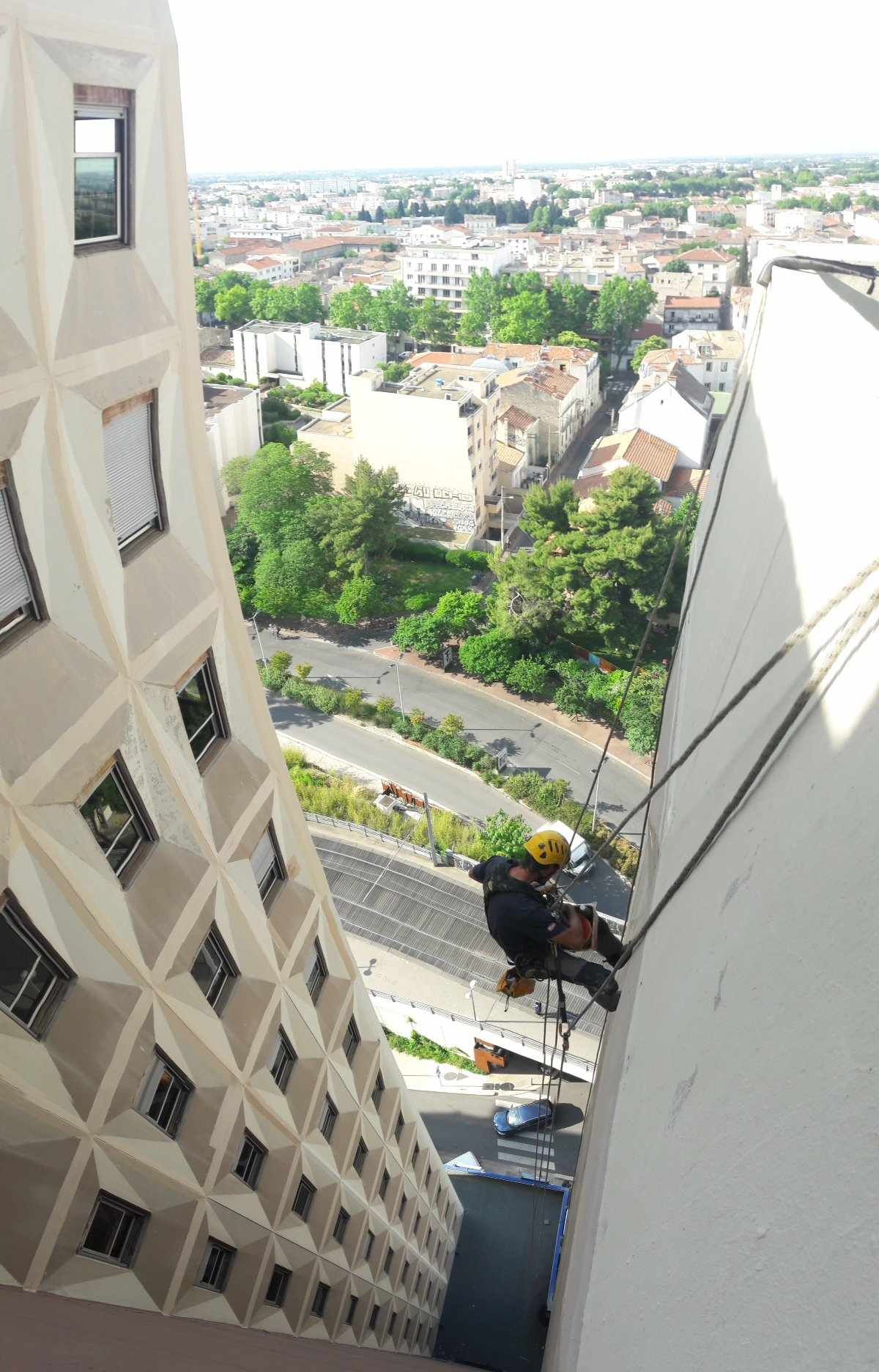 Un homme grimpe sur le côté d'un grand bâtiment.