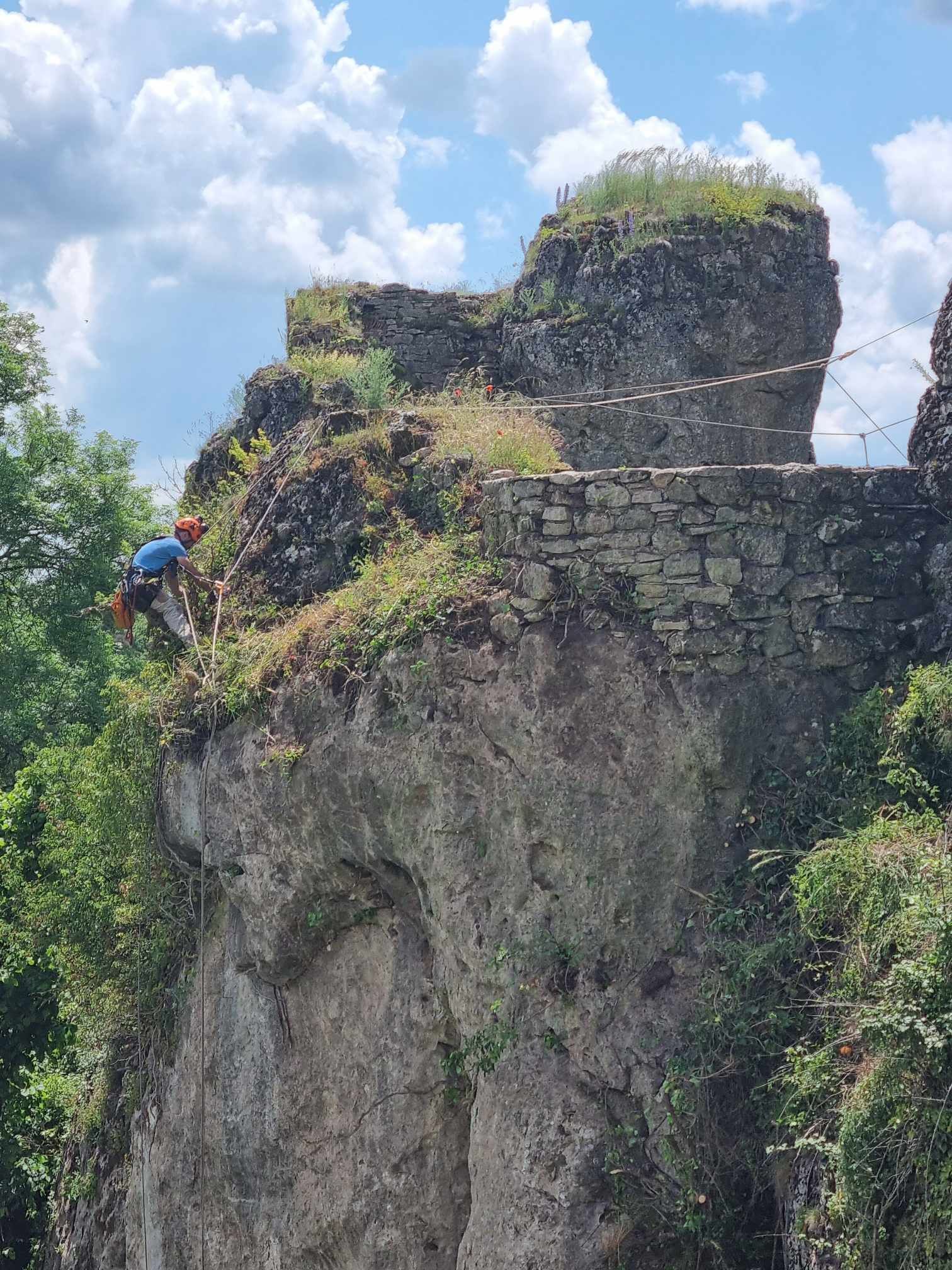 Un homme grimpe sur le flanc d'une falaise.