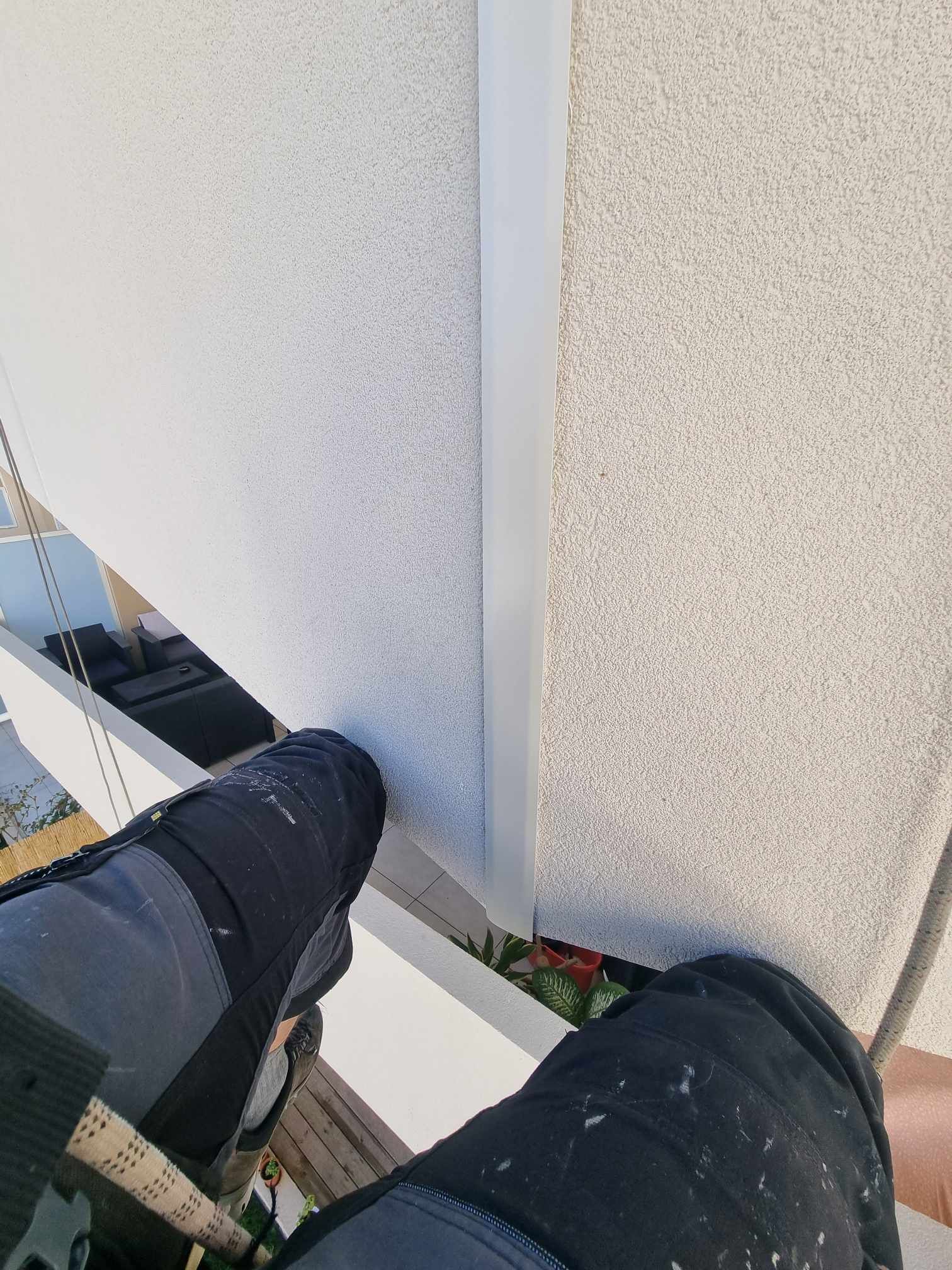 Une personne se tient sur un balcon à côté d'un bâtiment.