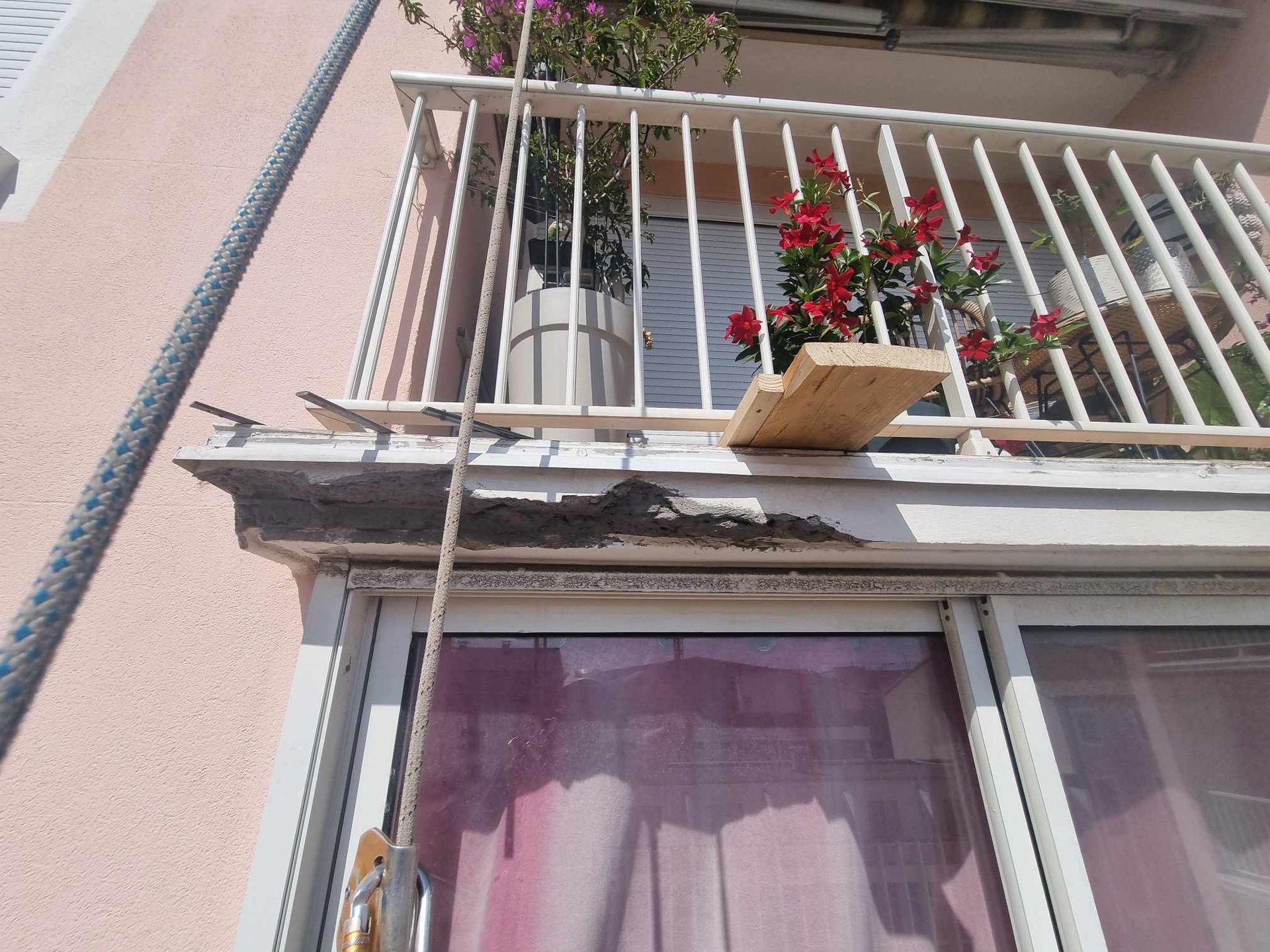 Un balcon avec des fleurs dans un pot dessus
