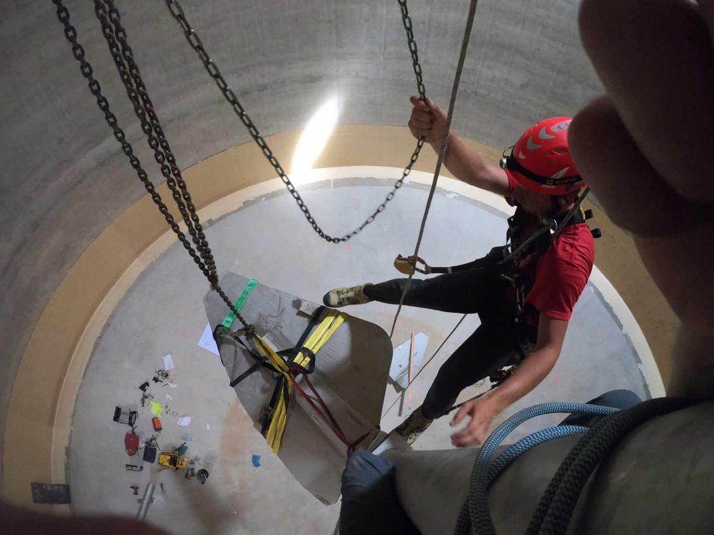 homme suspendu avec une corde dans du beton