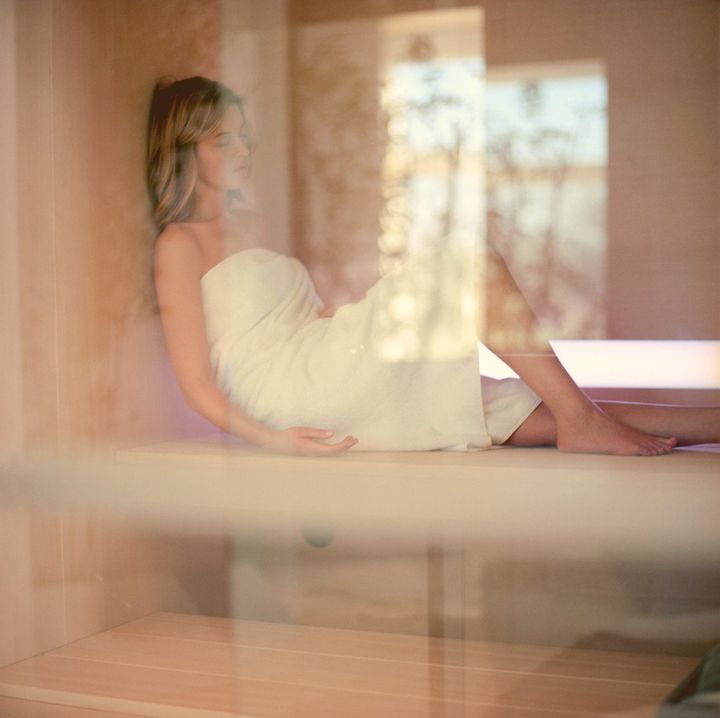 donna sdraiata in sauna durante una pausa di relax