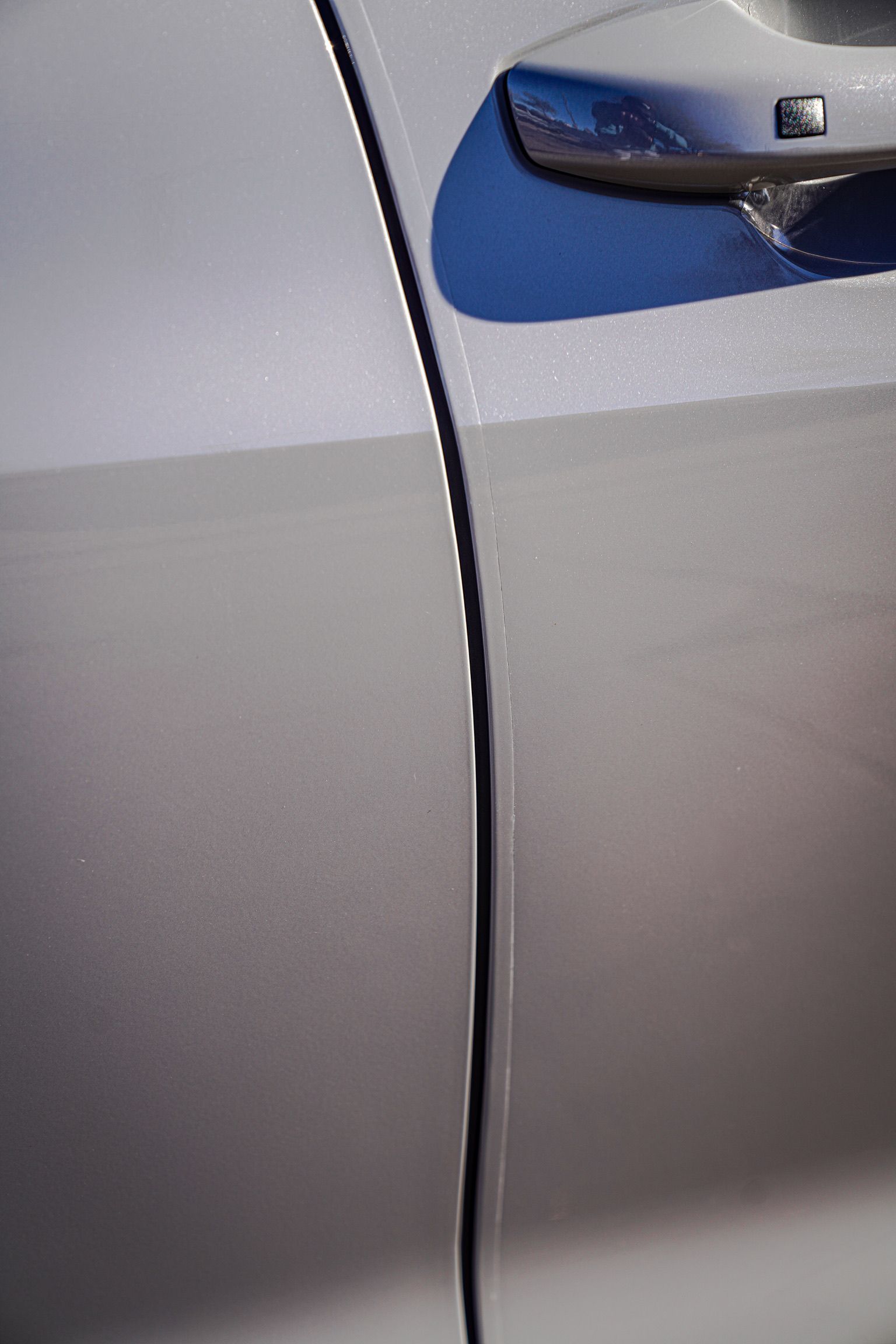 A close-up view of the seam between two silver car panels, showing a slight misalignment along the door edge.