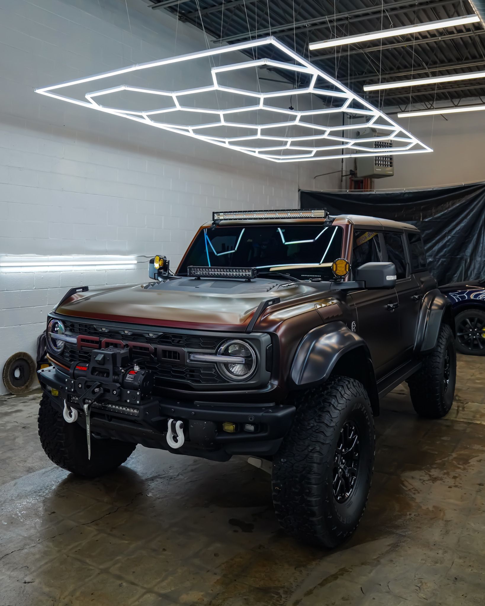 A blue Honda Civic Si parked in a dimly lit indoor parking garage.