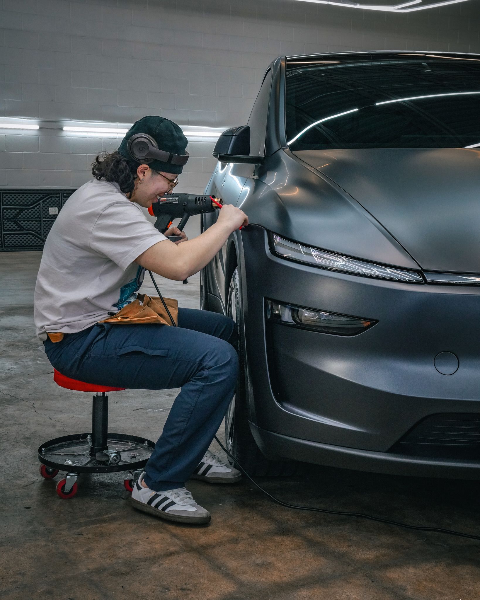 A close-up of a car's headlamp assembly, showing the sharp angle where the red painted frame meets the clear lens.