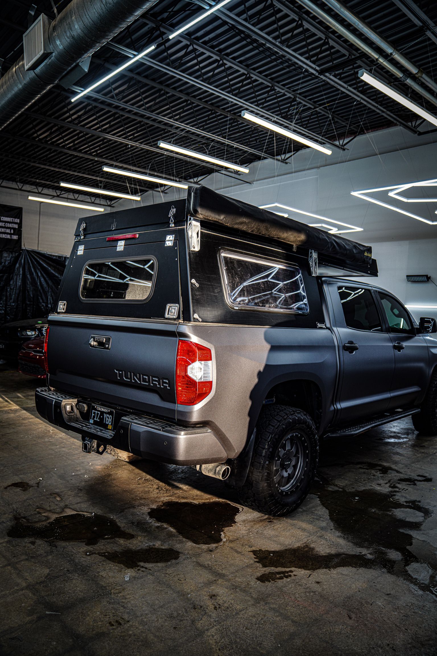A blue Honda Civic Si parked in a dimly lit indoor parking garage.
