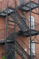A stainless steel double-basin sink sits between light wood cabinets and appliances against a tiled wall.