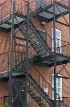 A stainless steel double-basin sink sits between light wood cabinets and appliances against a tiled wall.
