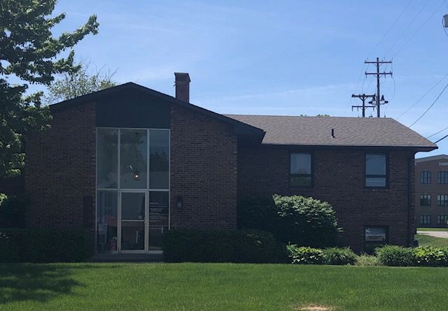 A large brick house with a large lawn in front of it