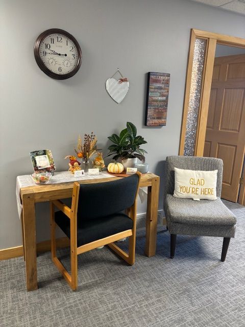 There is a clock on the wall above the desk.