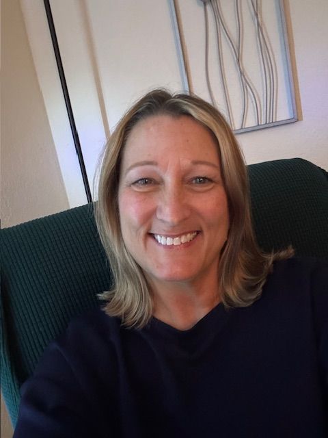 A woman is sitting in a chair talking to a man.