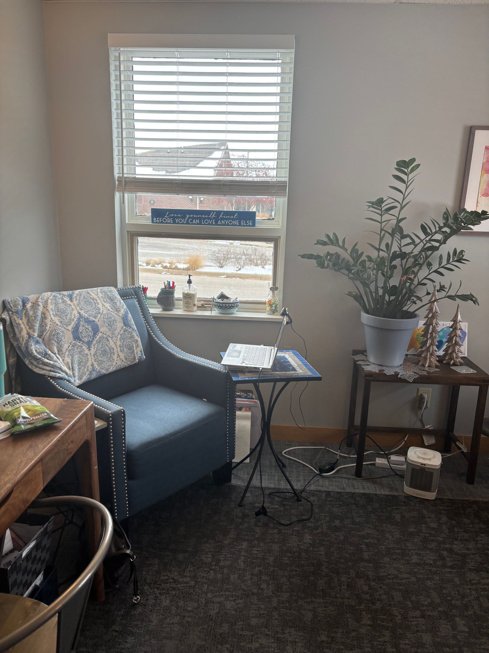 A living room with a blue chair and a window