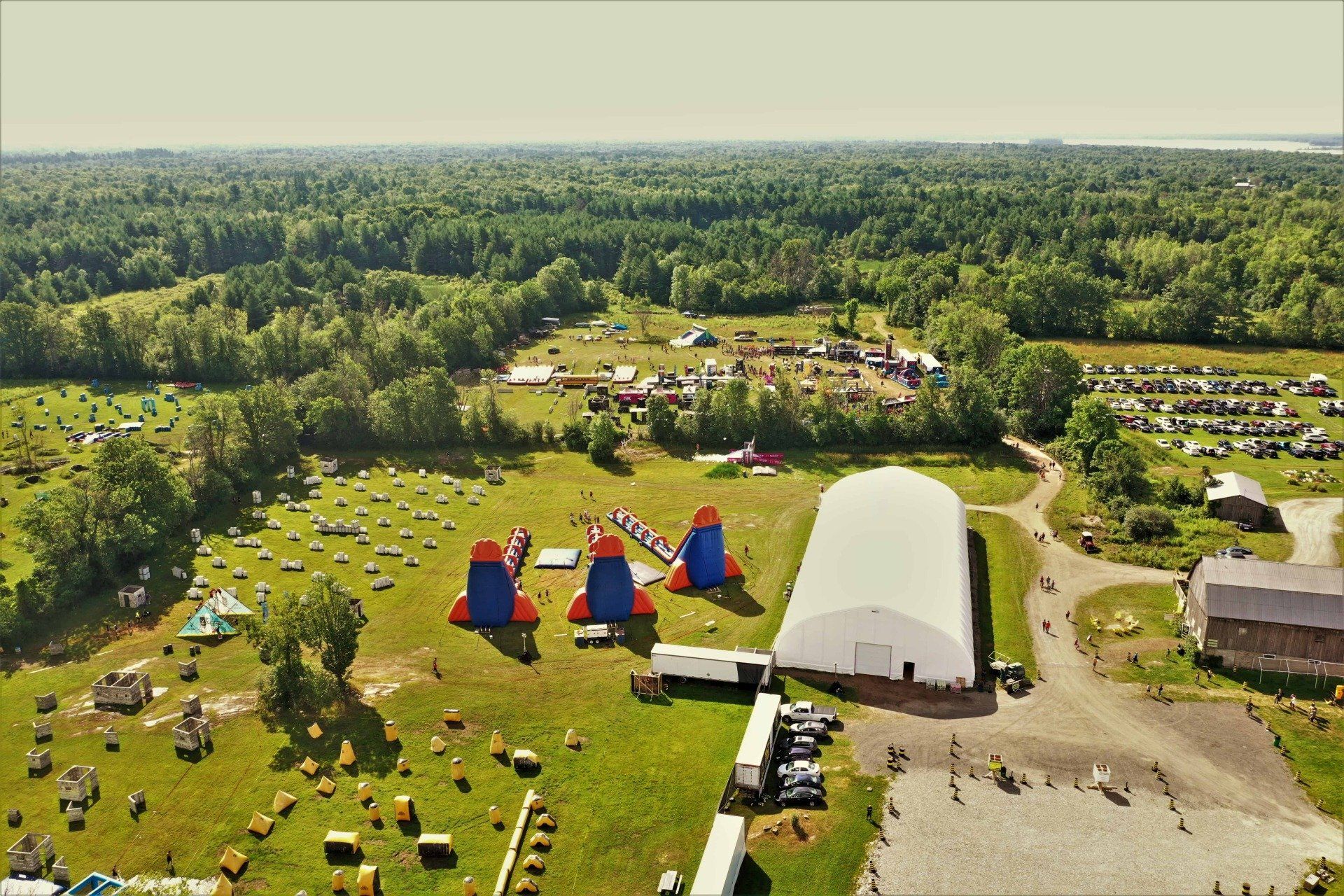 An aerial view of a paintball field with a large white building in the middle