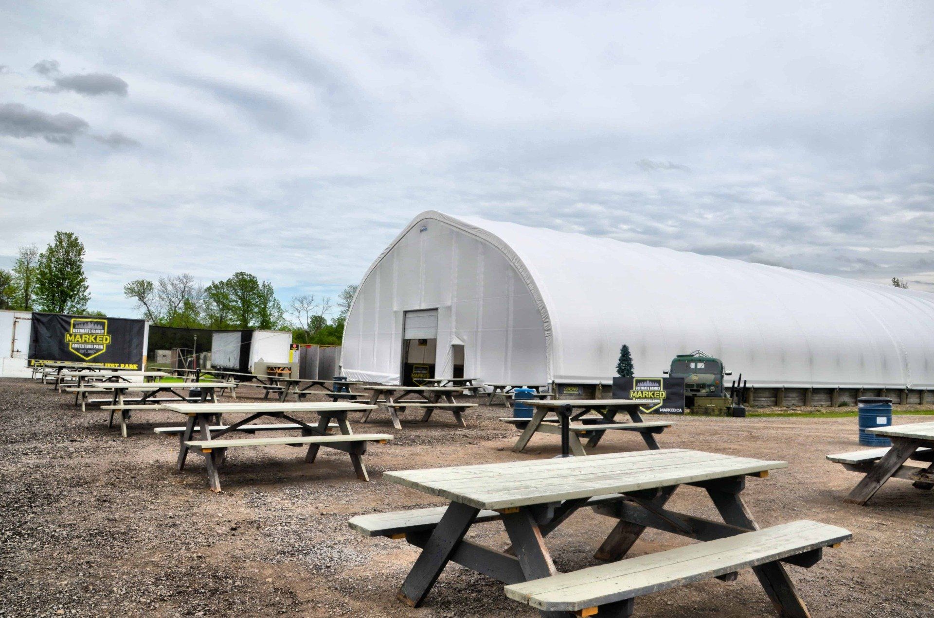 A large white building with a lot of picnic tables in front of it.