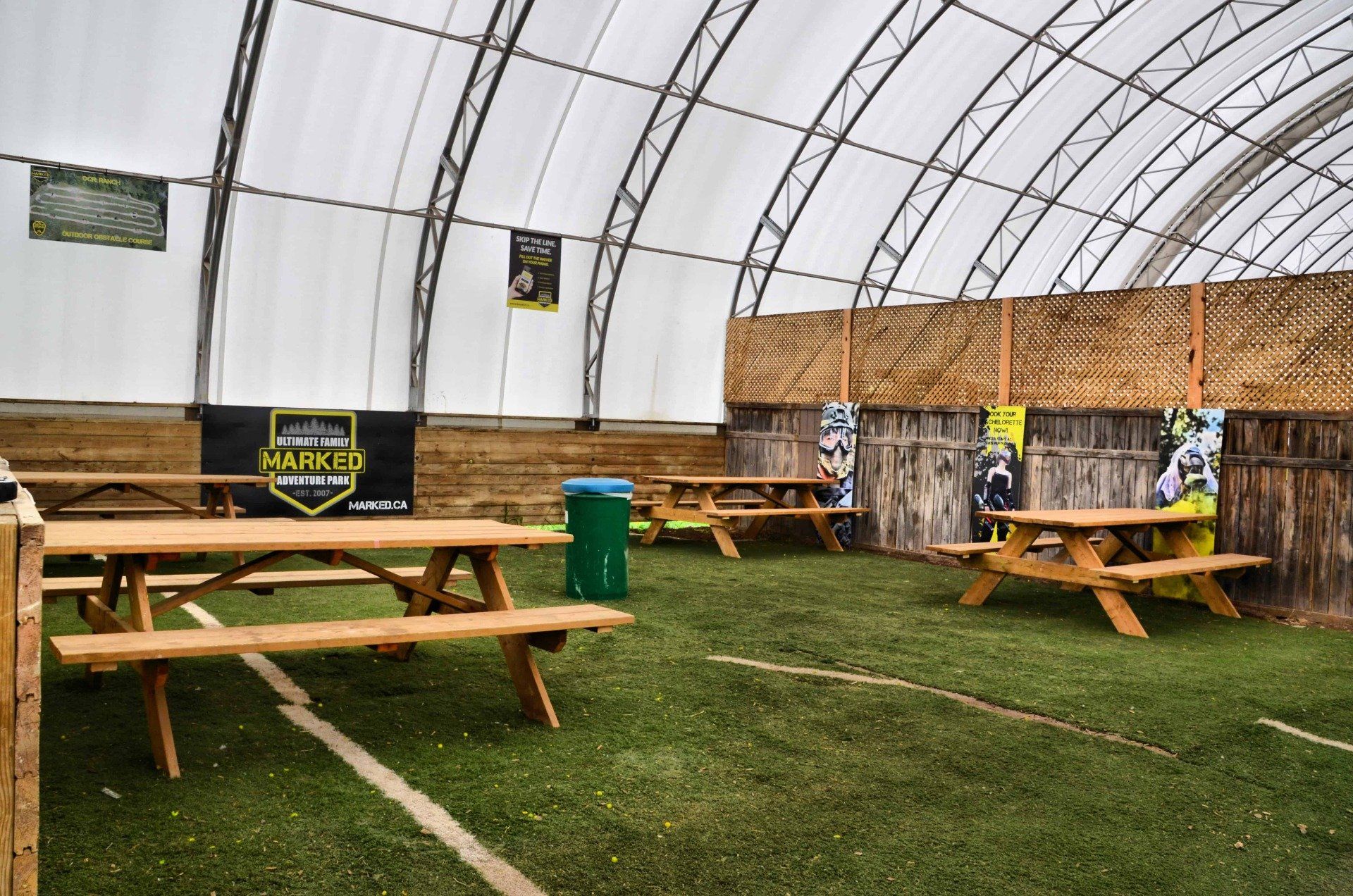 A group of picnic tables are sitting under a tent.