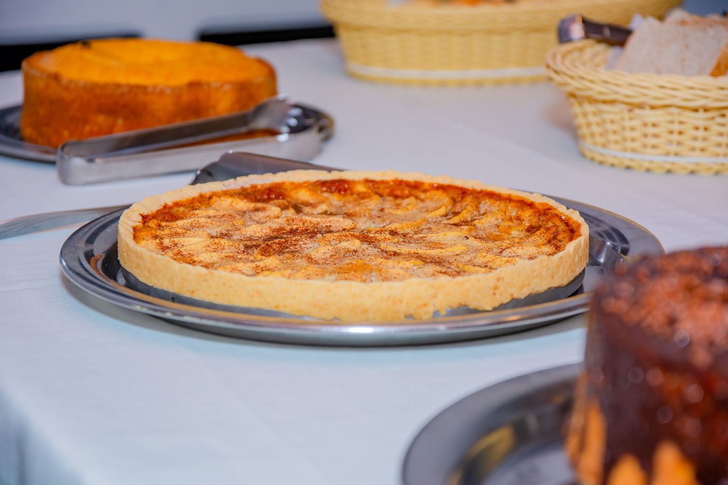 Uma pizza está em uma bandeja sobre uma mesa.