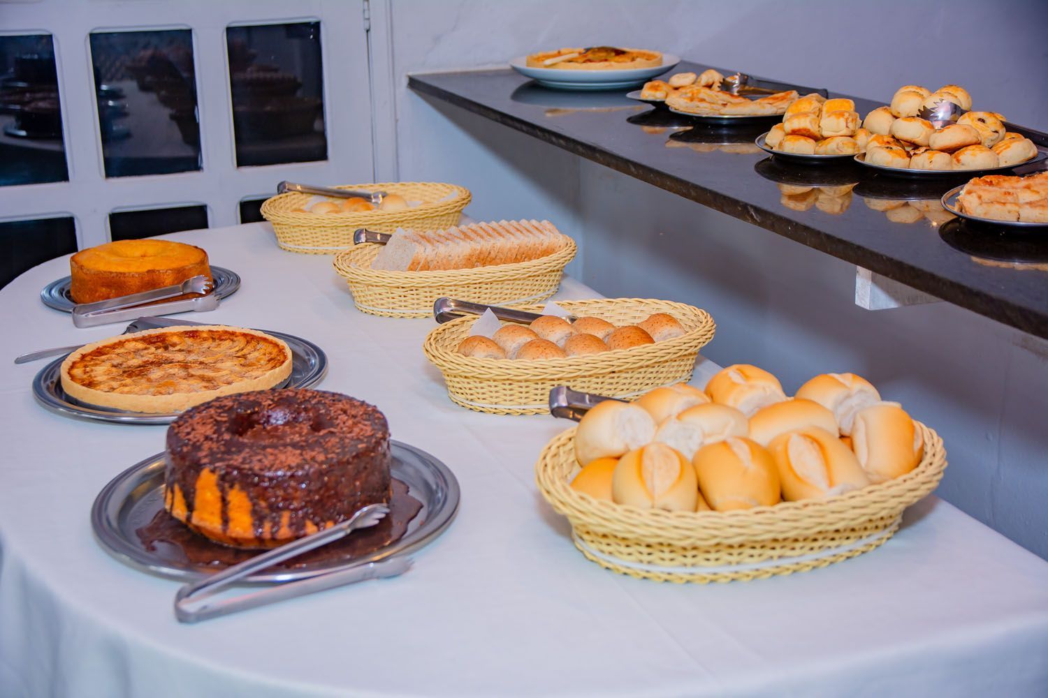 Uma mesa coberta com uma variedade de doces e pães.