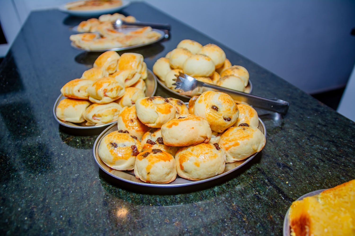 Uma mesa coberta com pratos de doces e pinças.