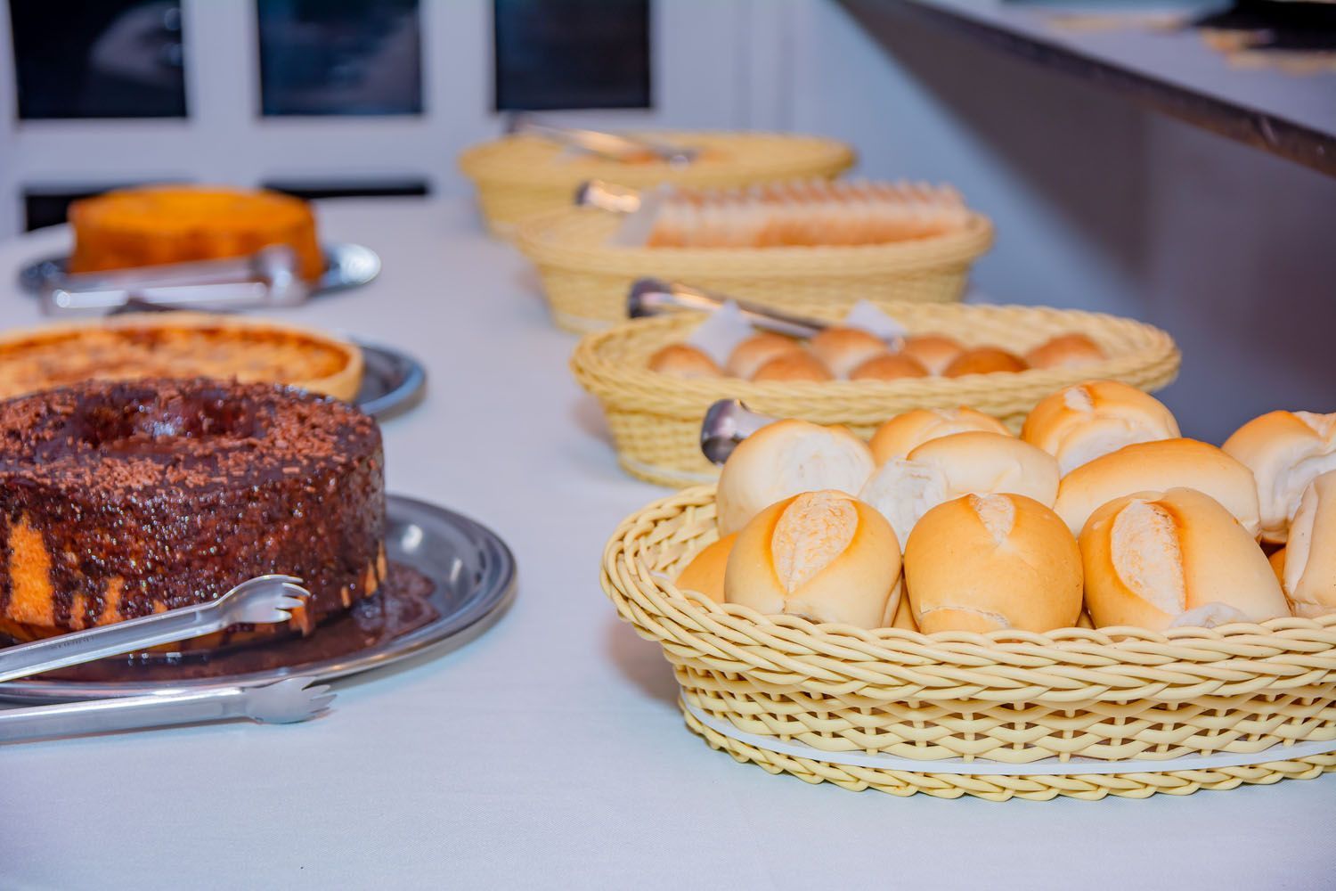 Uma mesa coberta com uma variedade de doces e cestas de pão.