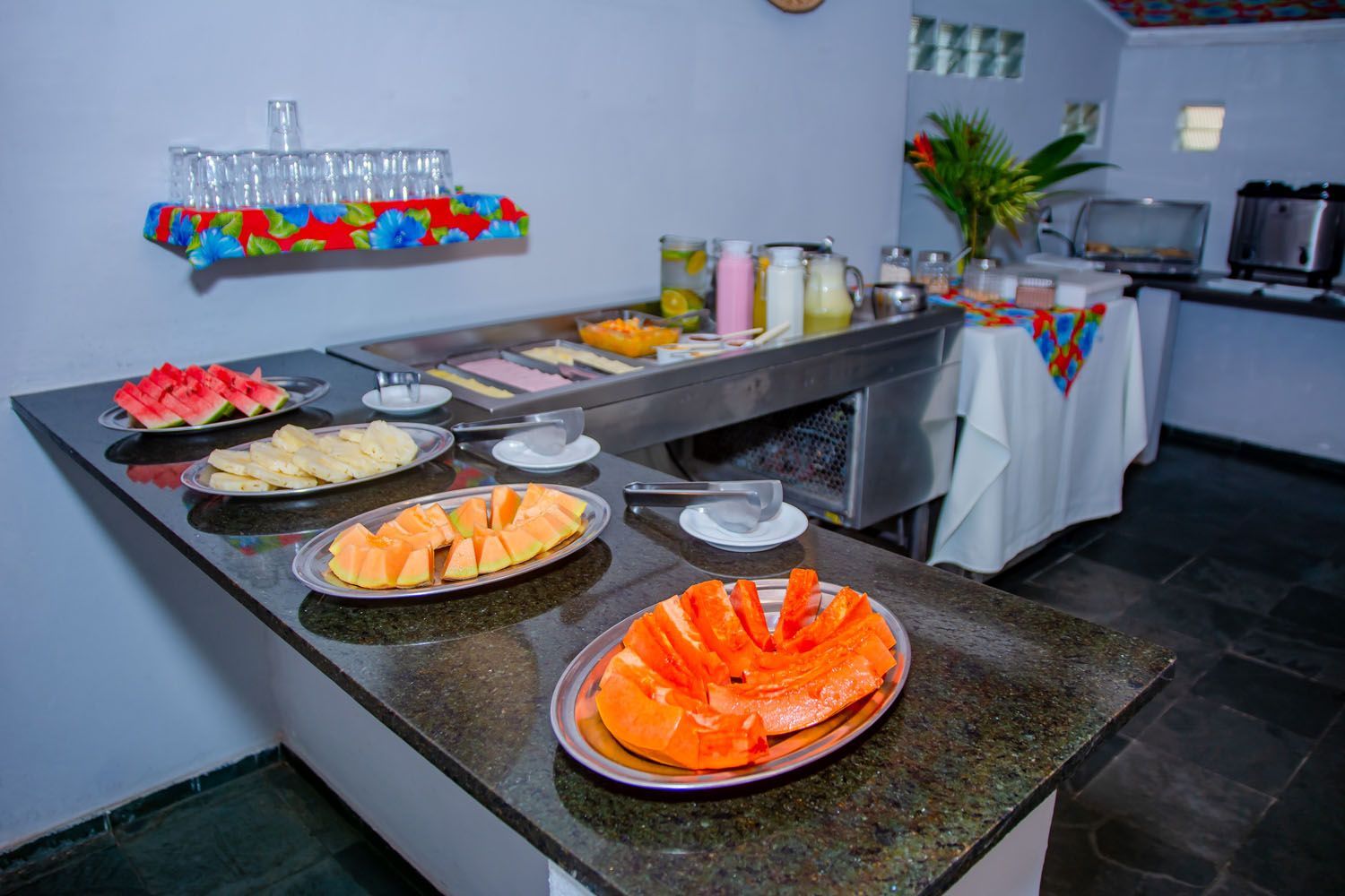 Uma mesa de bufê com pratos de frutas.