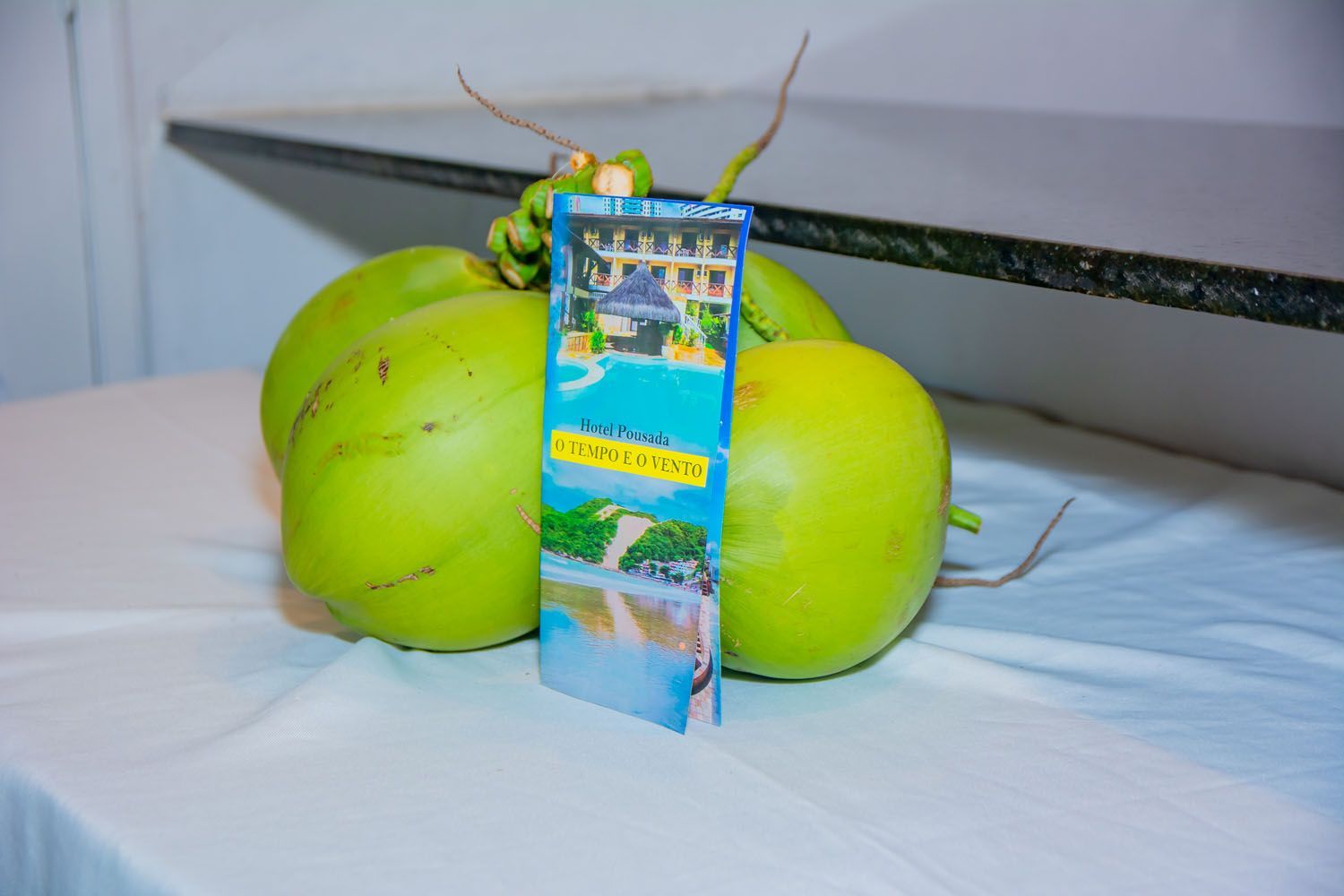 Um monte de cocos está sobre uma mesa com um marcador em cima deles.