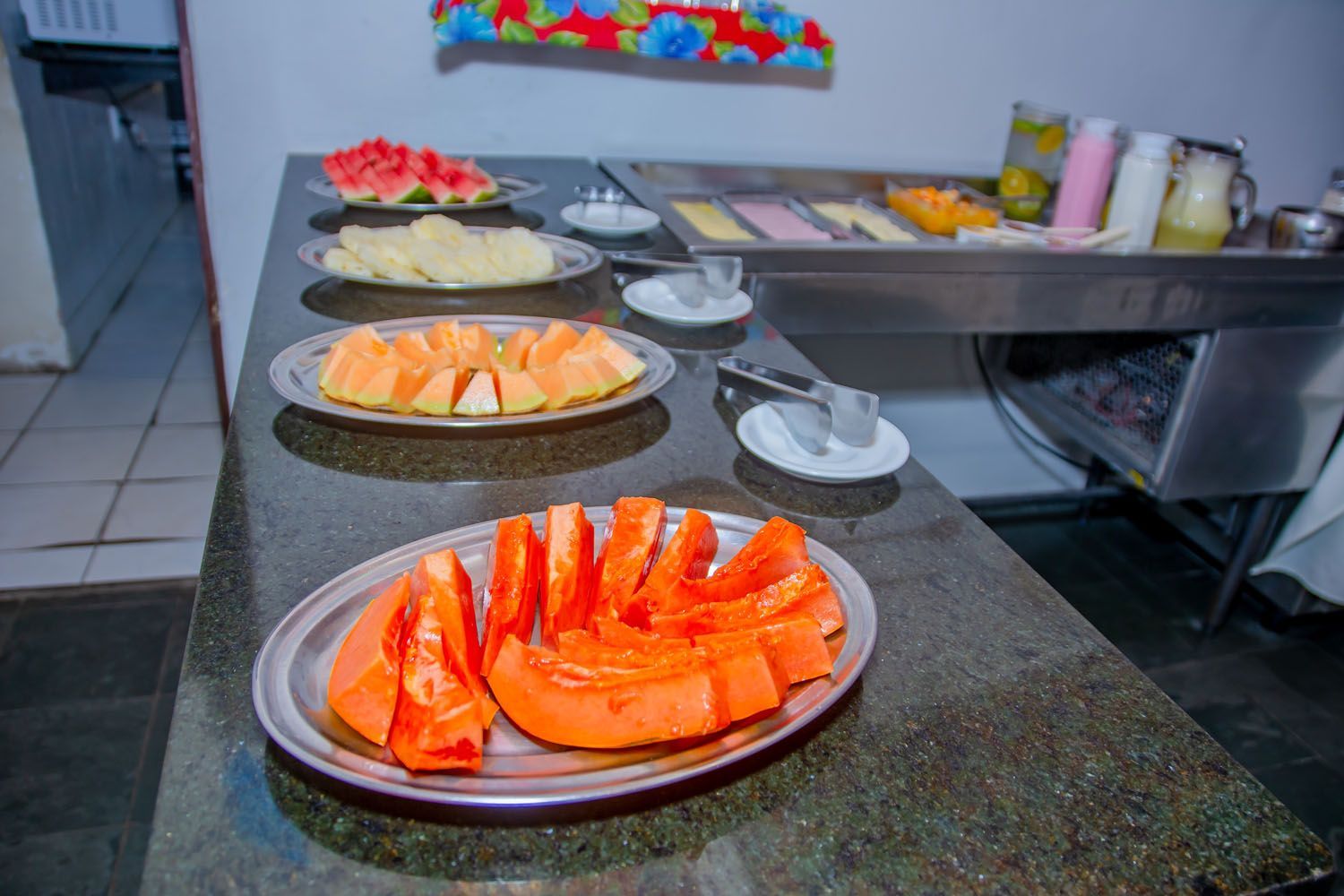 Uma mesa de bufê com pratos de frutas.