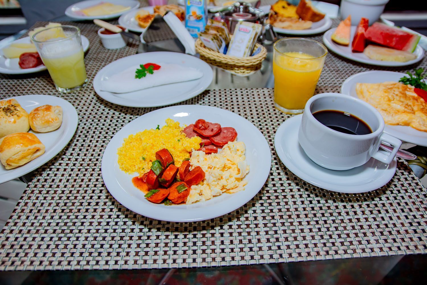 Uma mesa com pratos de comida e uma xícara de café.