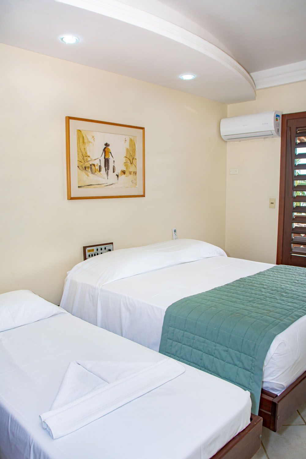 Um quarto de hotel com duas camas e um quadro na parede.