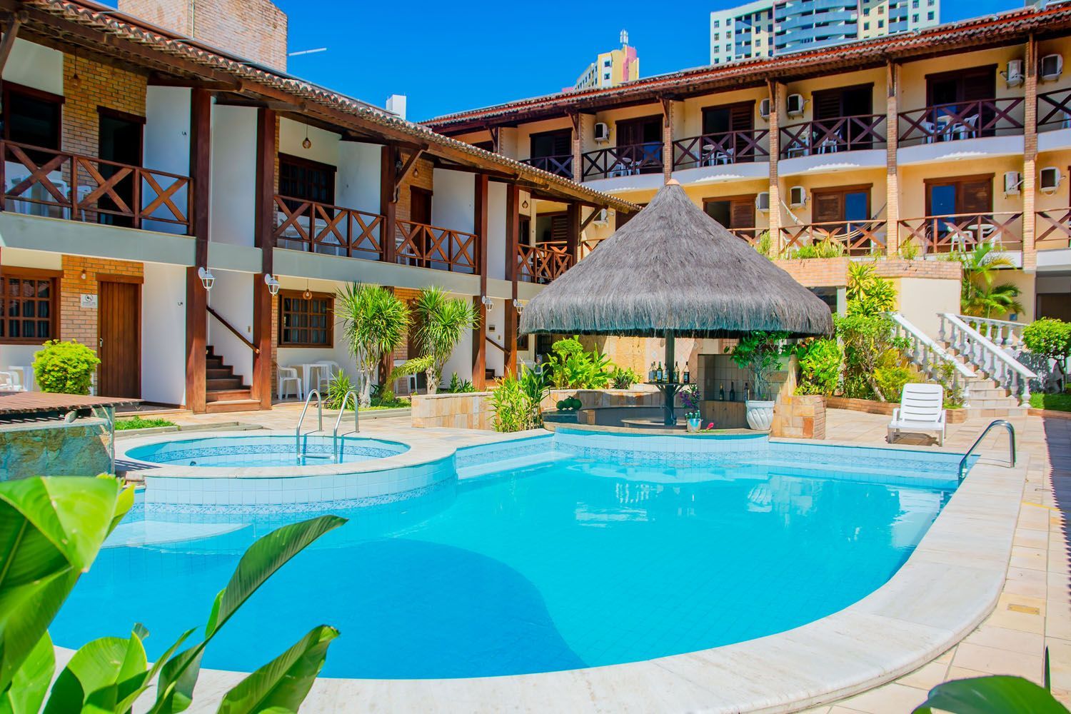 Há uma grande piscina no meio de um hotel.