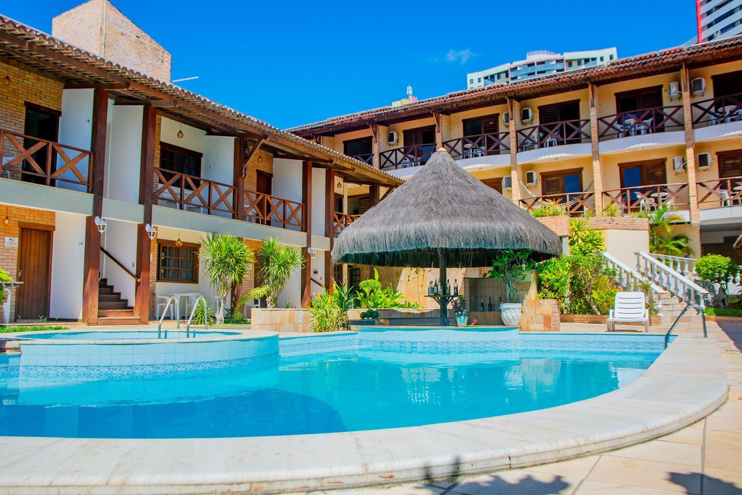 Há uma grande piscina no meio de um hotel.