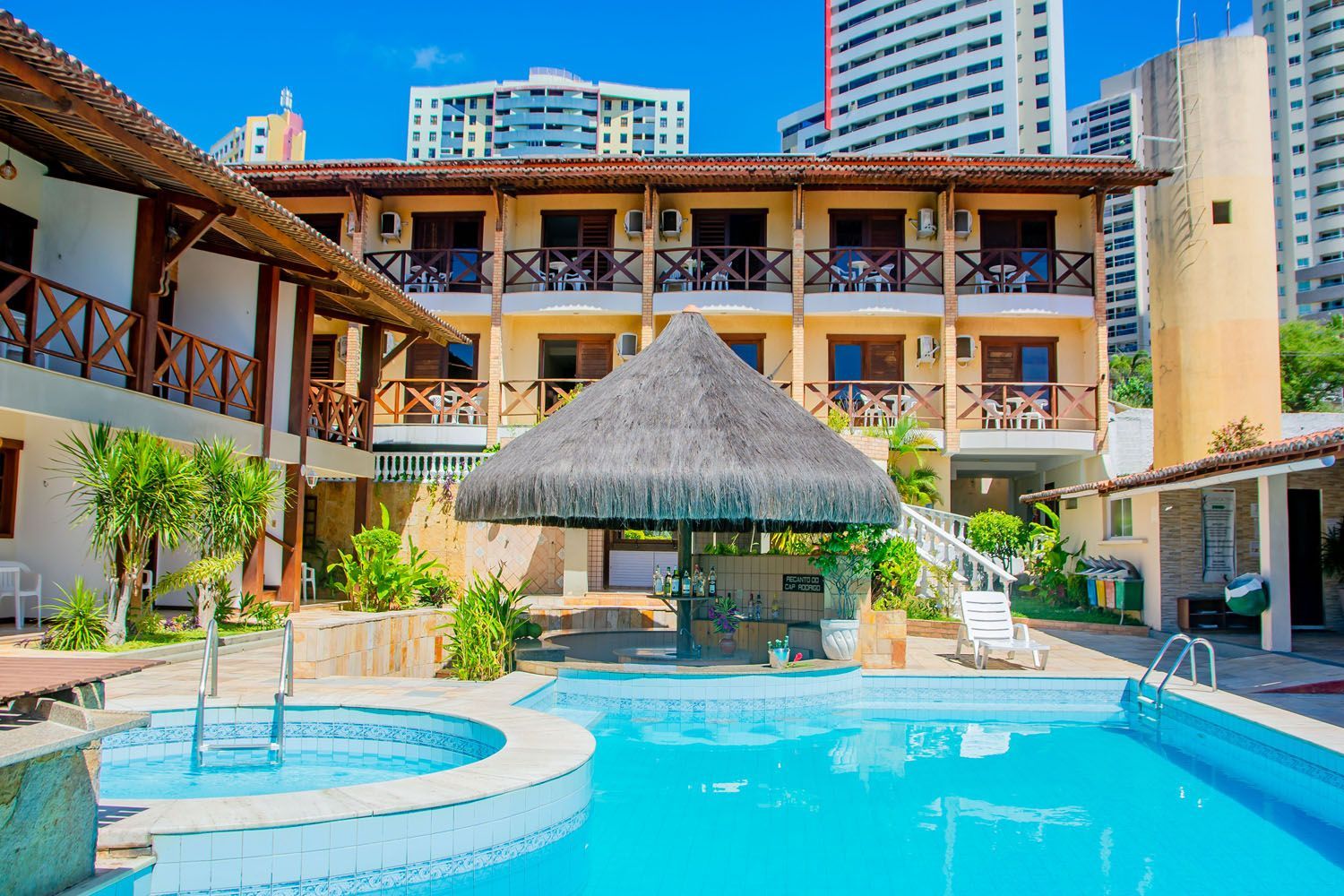 Há uma grande piscina no meio de um hotel.