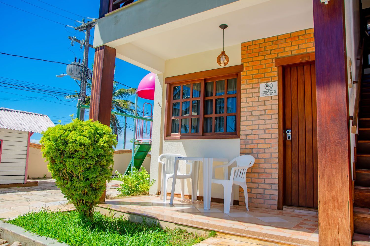 Uma casa de tijolos com mesa e cadeiras na varanda.