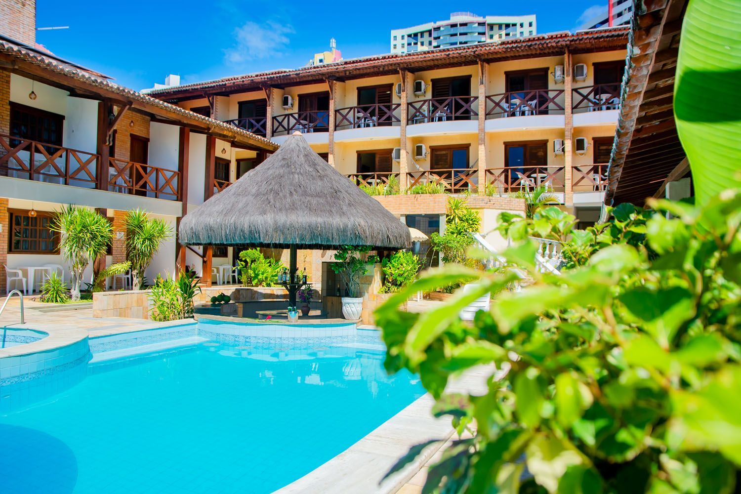 Há uma piscina no meio de um hotel.